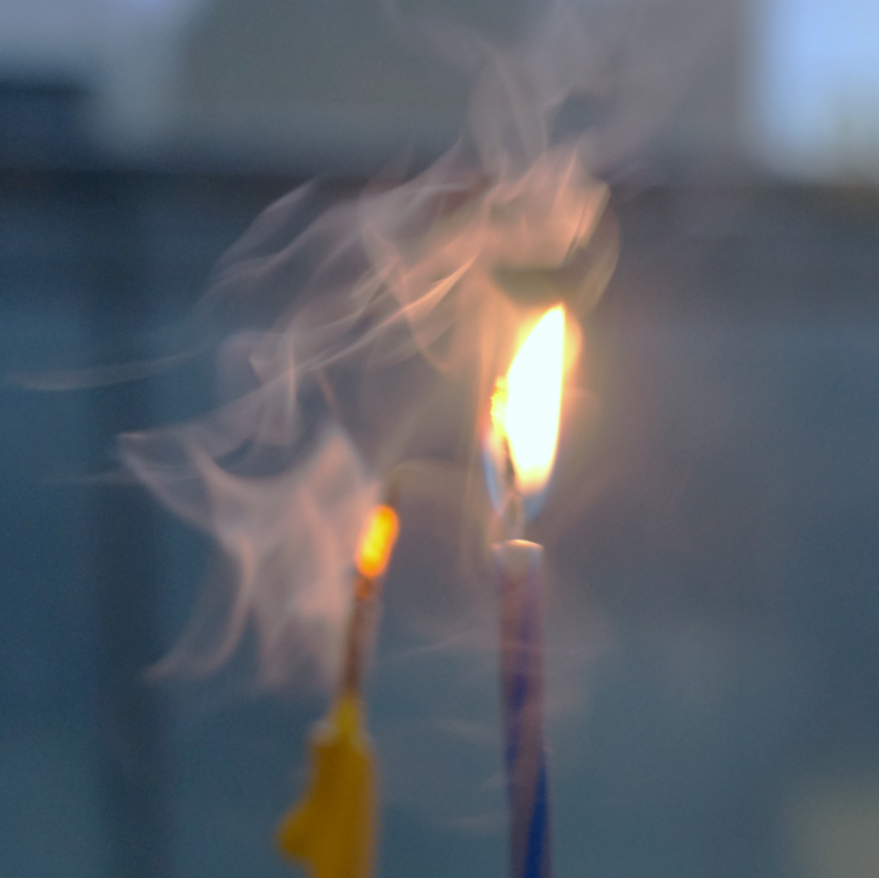 Smoke curling around a small flame