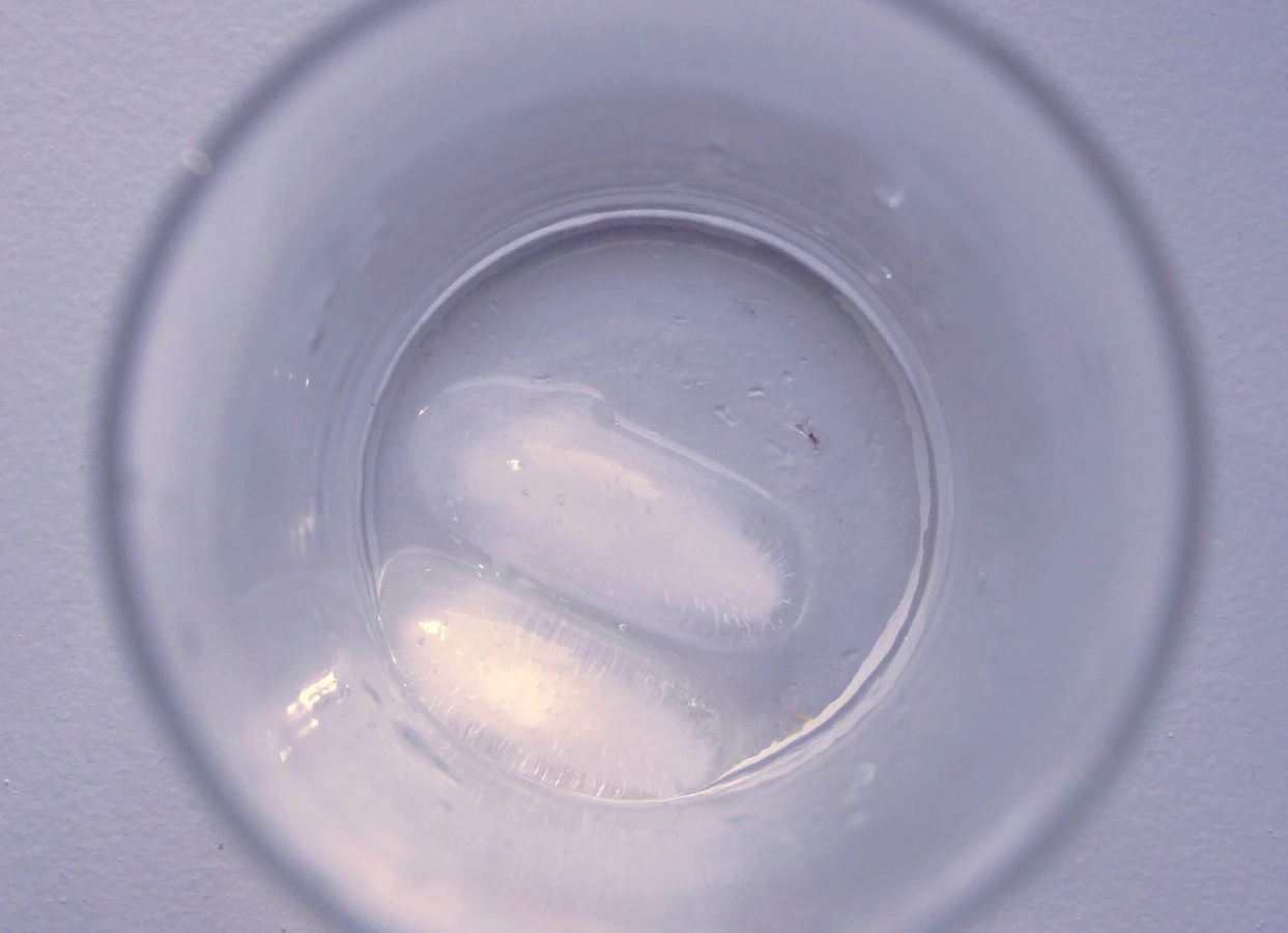 Ice floating in a clear glass, photographed from above
